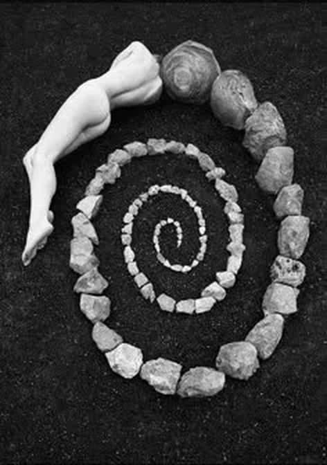 A spiral laid out in stones on dark ground
